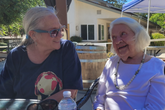 Two women smile at each other