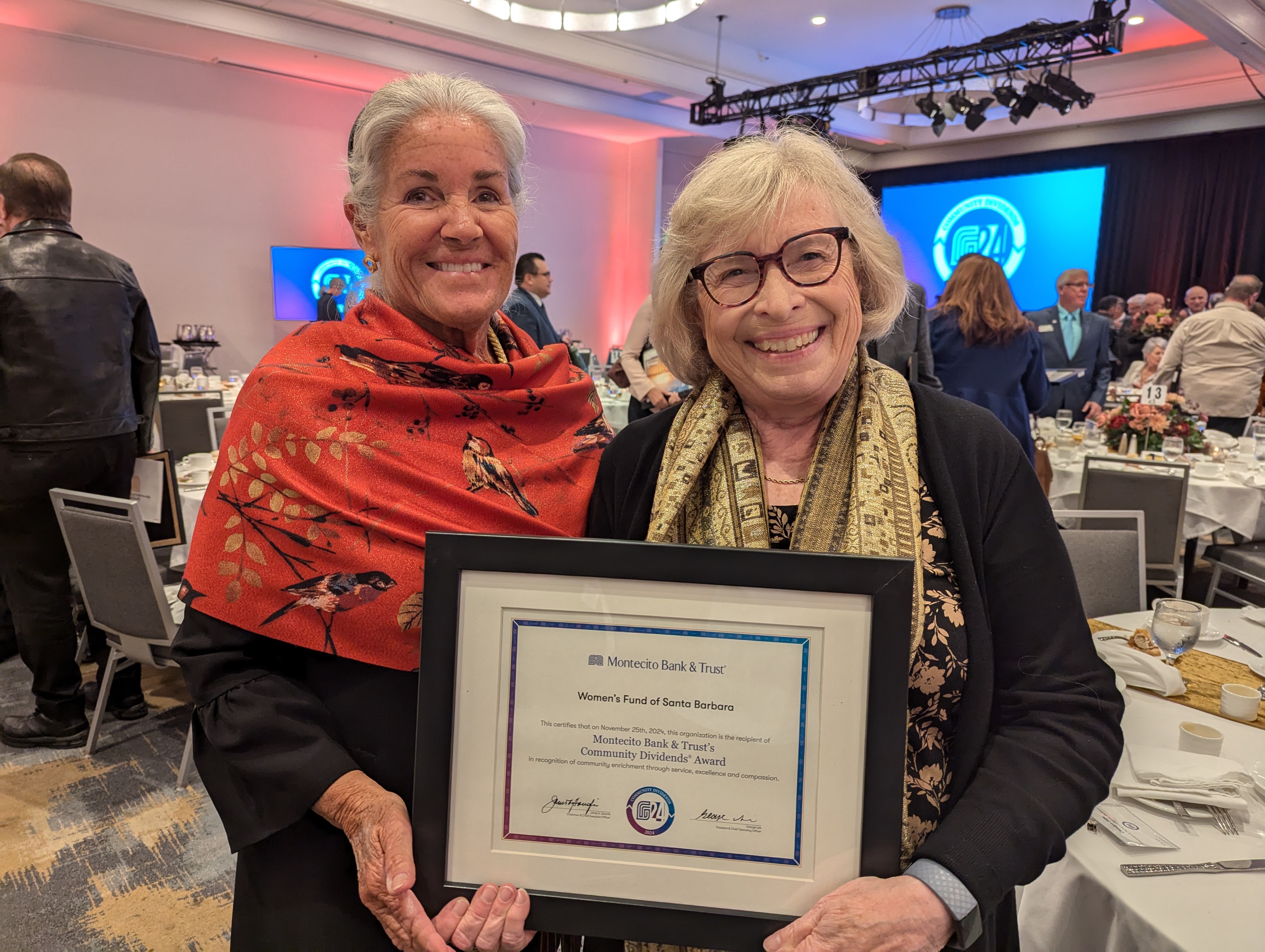  Suzi Schomer and Carolyn Jabs hold a framed Community Dividends certificate