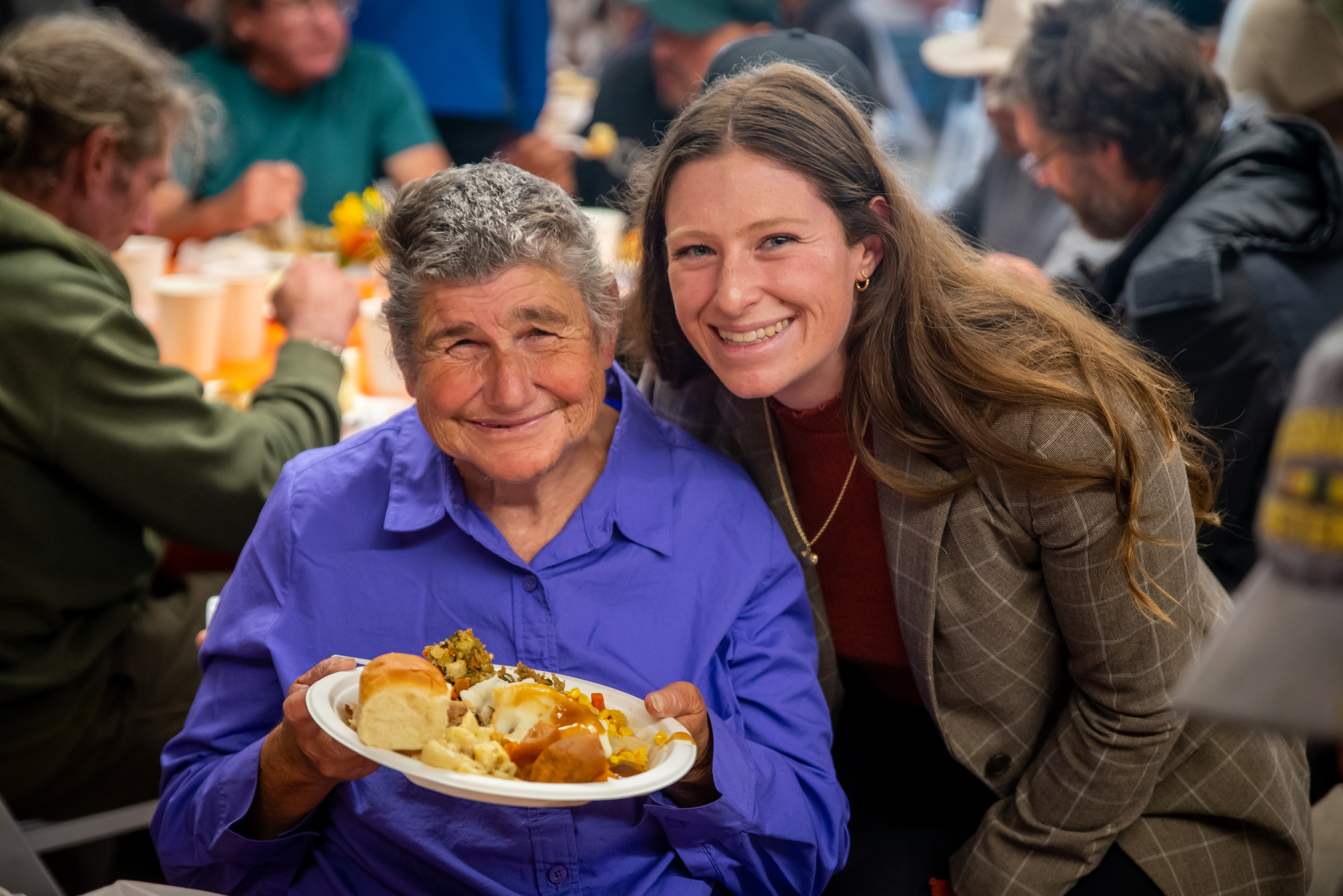 Women smiling over warm meal