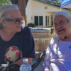 Two women smile at each other