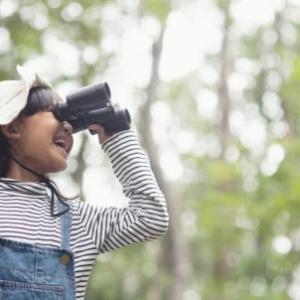young girl looking through binoculars