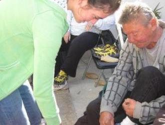 Casa Esperanza: man putting on a shoe with assistance