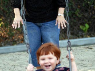 CASA Woman with child in playground swing