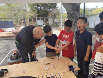 Harding Elementary School Teacher assists boy with project