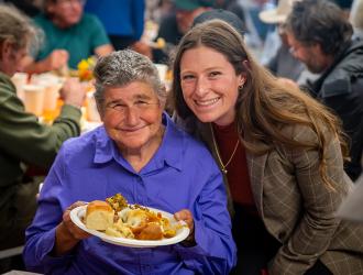 Women smiling over warm meal