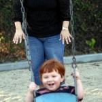 CASA Woman with child in playground swing