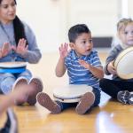 young children playing musical instruments with teacher