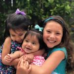 Three smiling, hugging girls