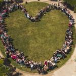 Aerial view of people standing forming a heart