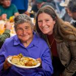 Women smiling over warm meal