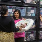 Volunteer handing baby items to woman