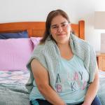 Woman sitting on bed smiling